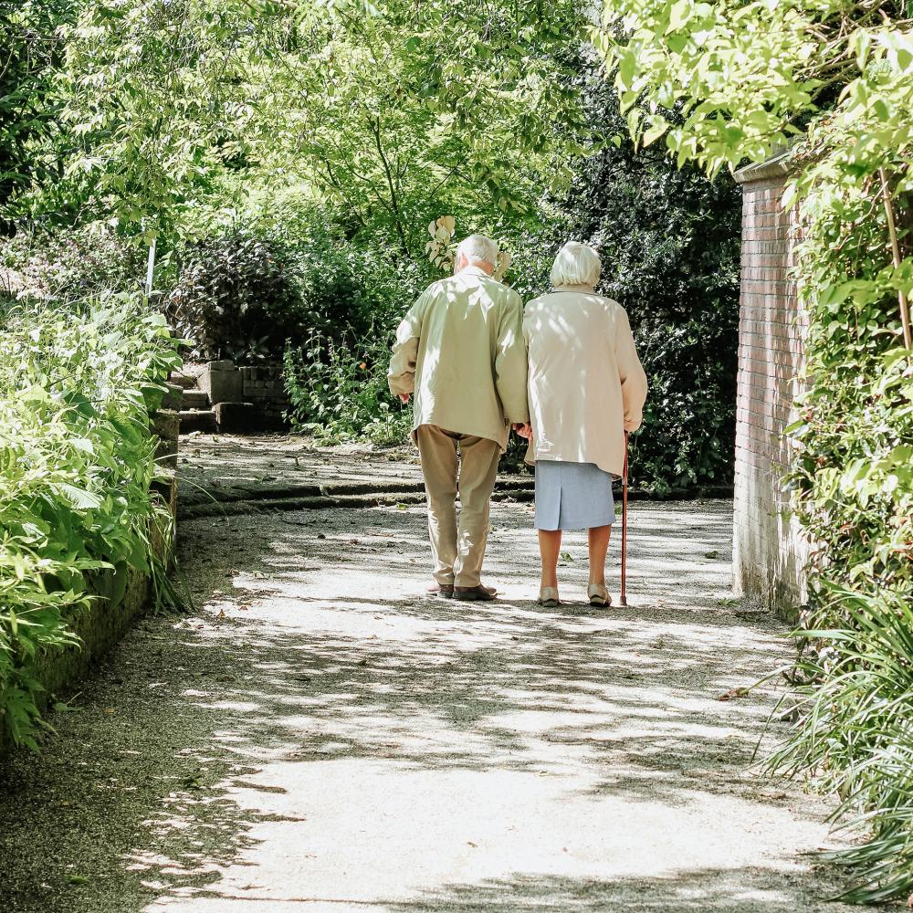 An elderly couple walking down a quiet path