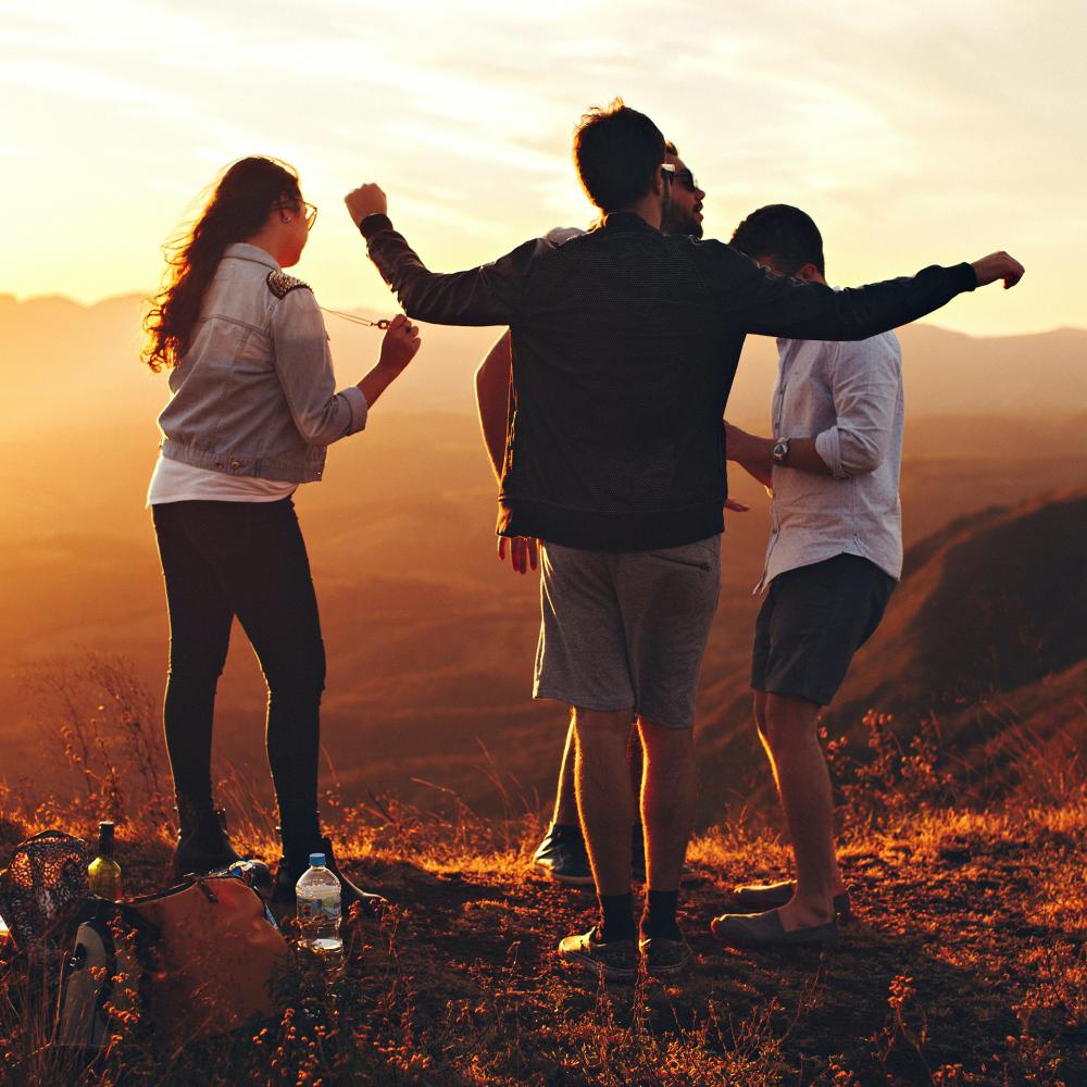 A group of friends dancing on top of a hill